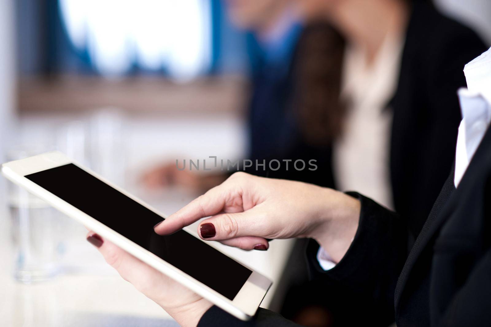Corporate lady working on tablet device by stockyimages