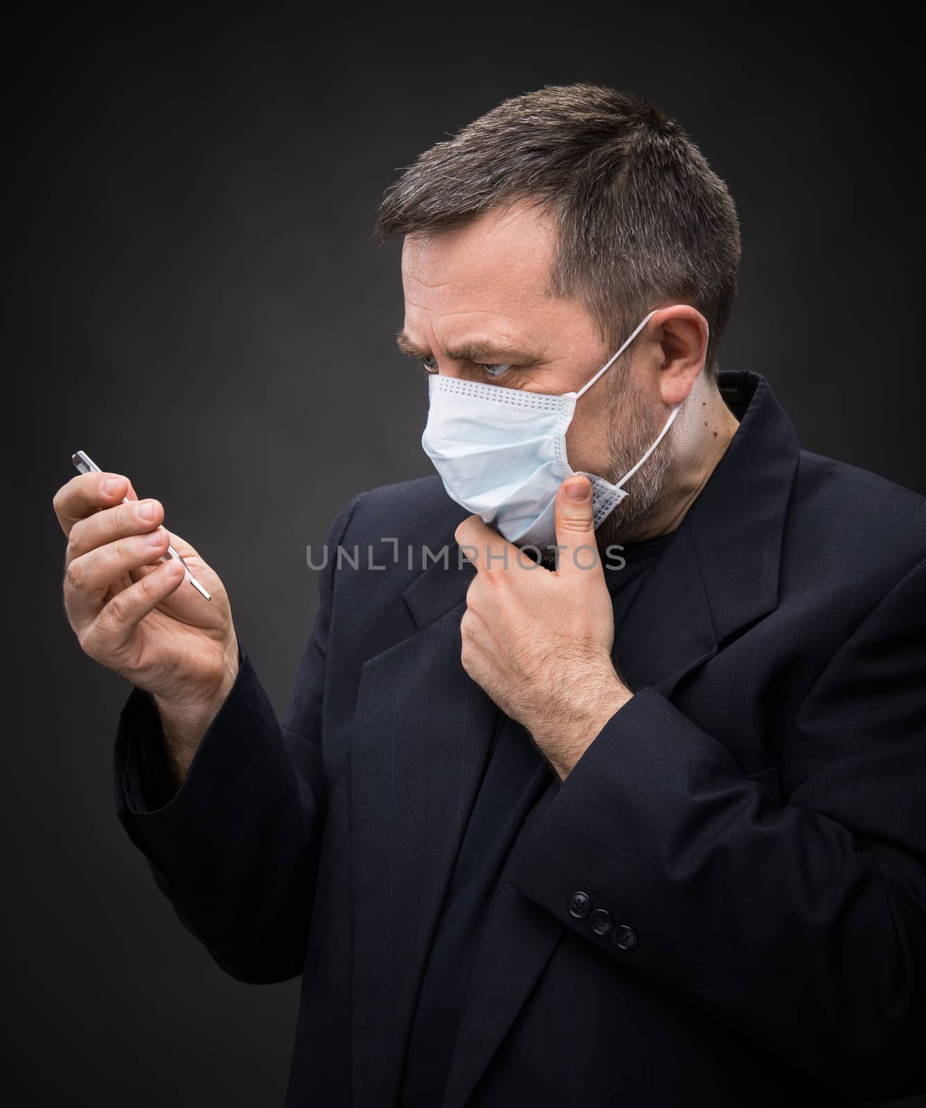 Illness. Man in medical mask with a thermometer