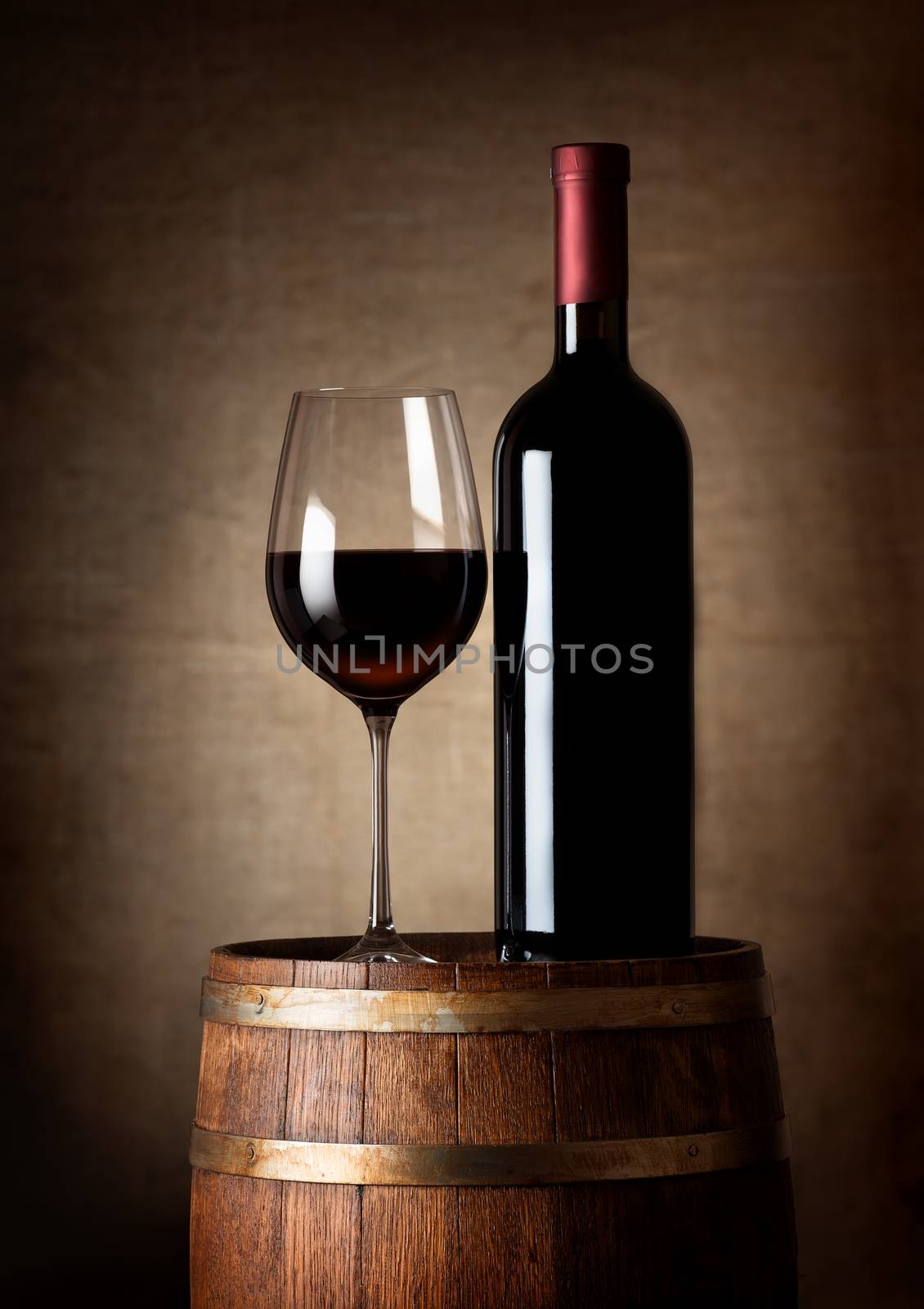 Wine standing on a barrel on a background of a canvas