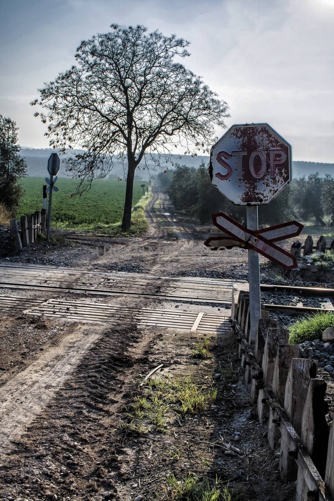 Warning sign worn of level crossing without barriers, blue sky with clouds