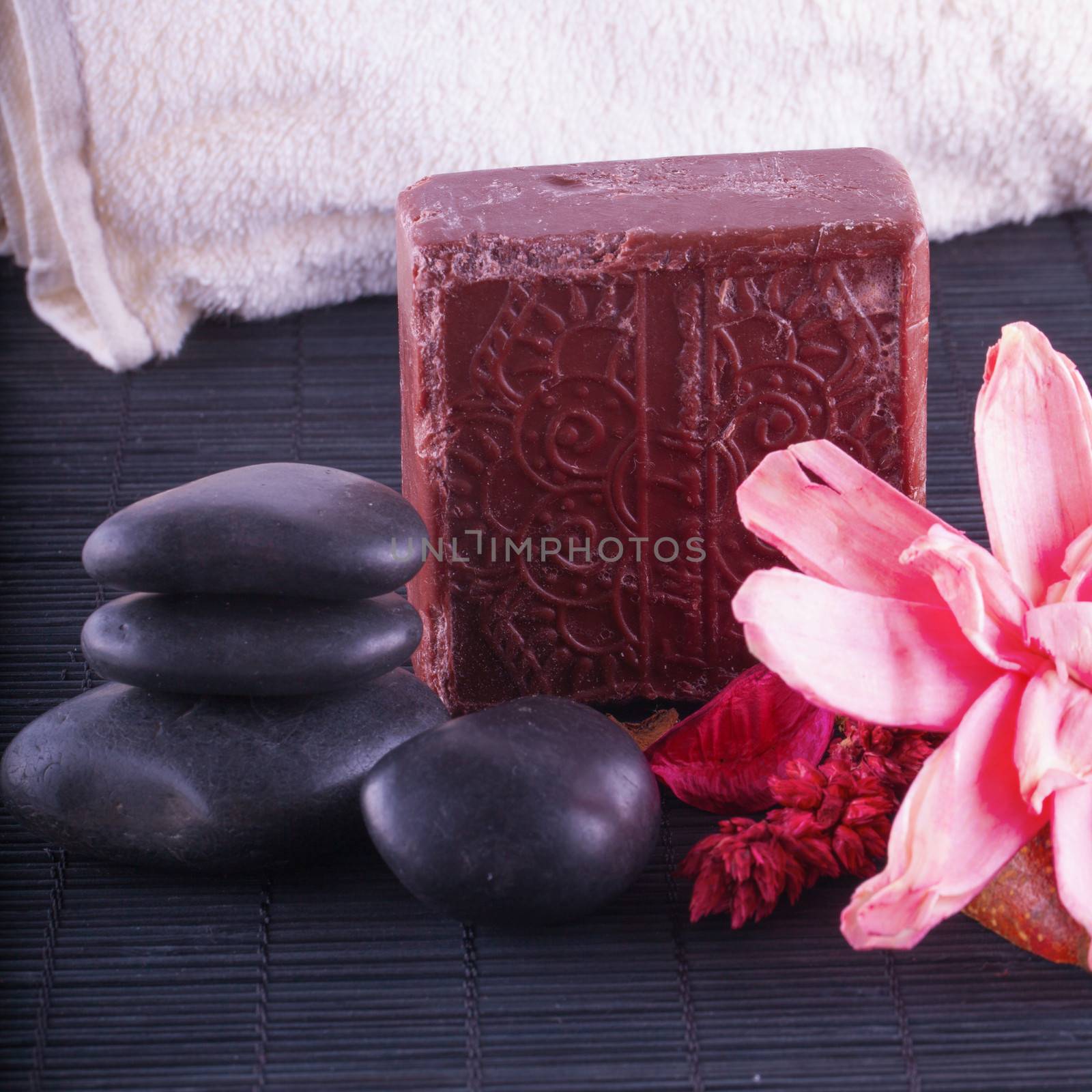 Hammam interior, with brown soap, stones, towel and flowers