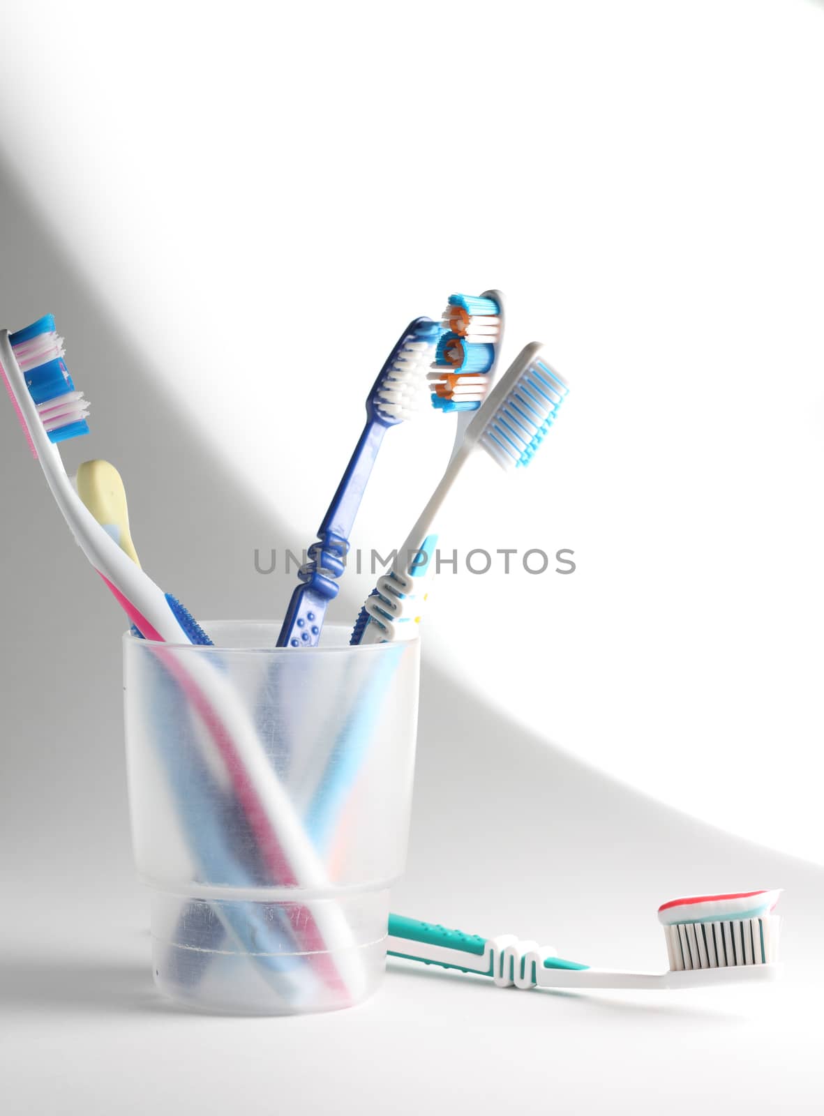 Some toothbrushes in a plastic glass