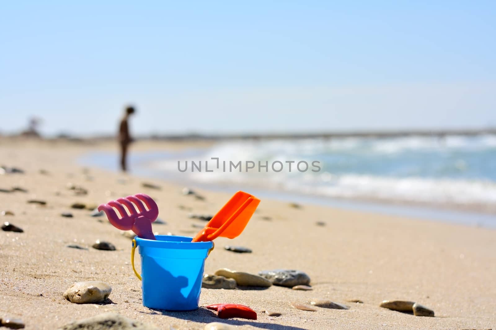 Plastic bucket on the beach near the sea