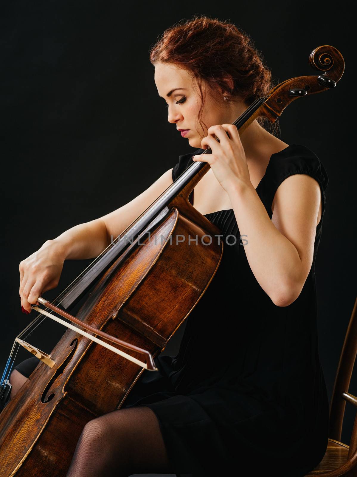 Photo of a beautiful woman playing an old cello.