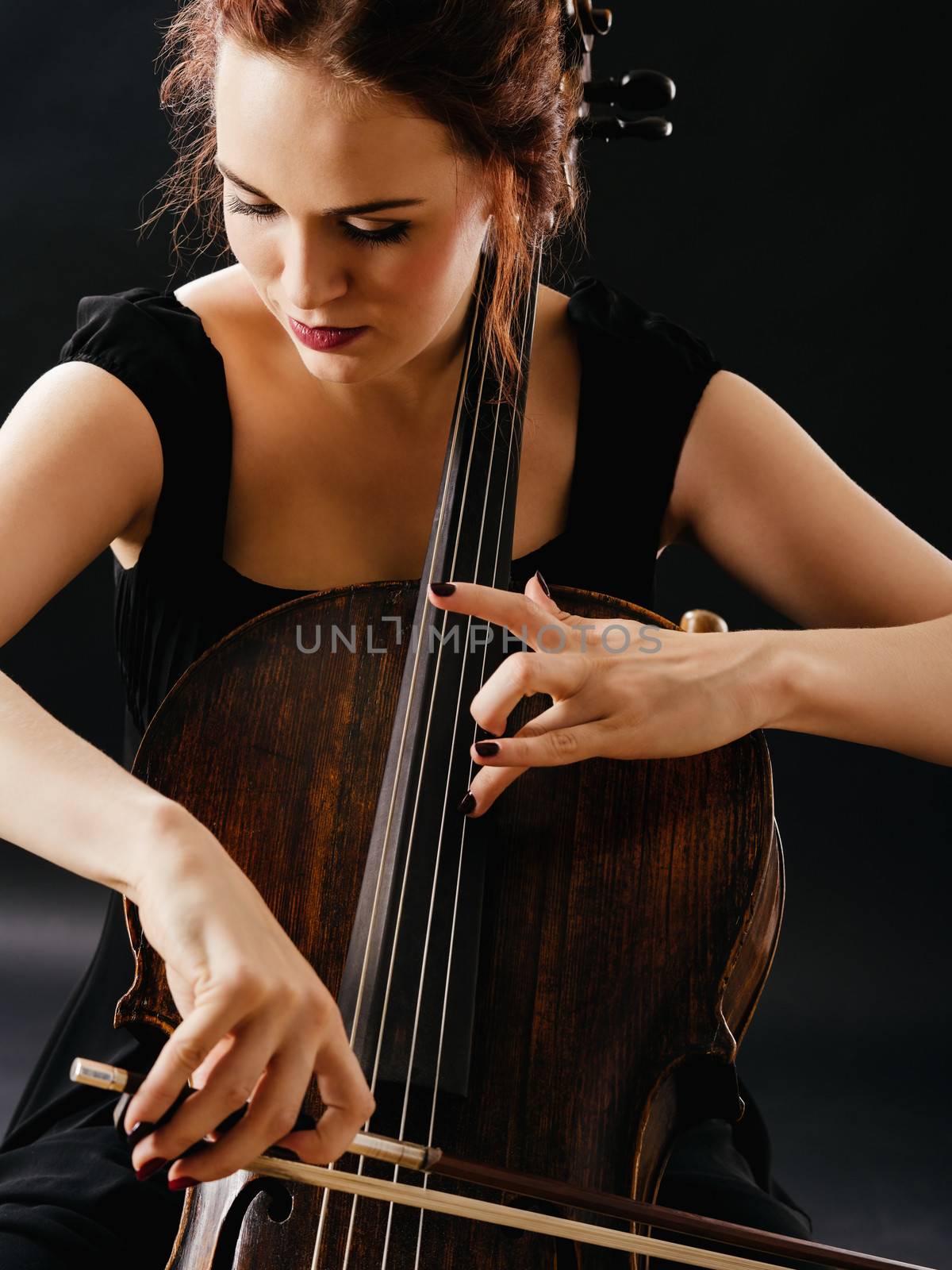 Photo of a beautiful woman playing an old cello.