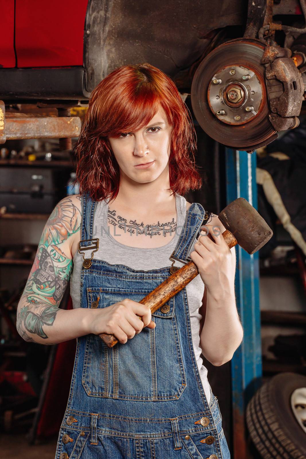 Female mechanic holding rubber mallet by sumners