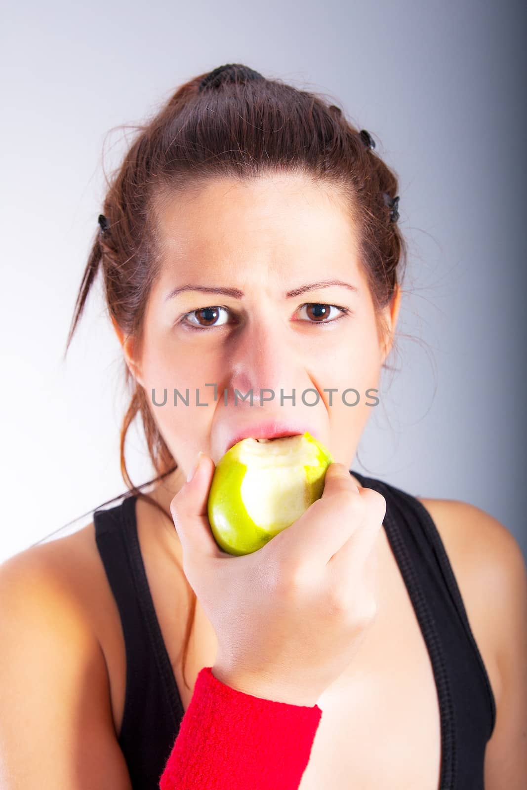 Beautiful young woman eating  apple by dukibu