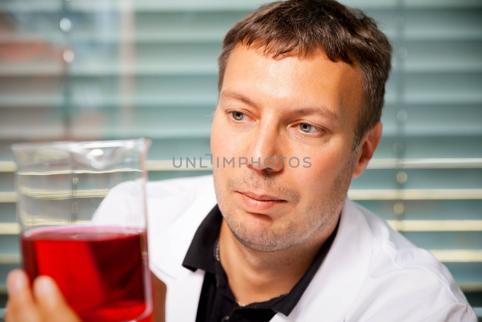 A man with red and yellow liquid in a laboratory