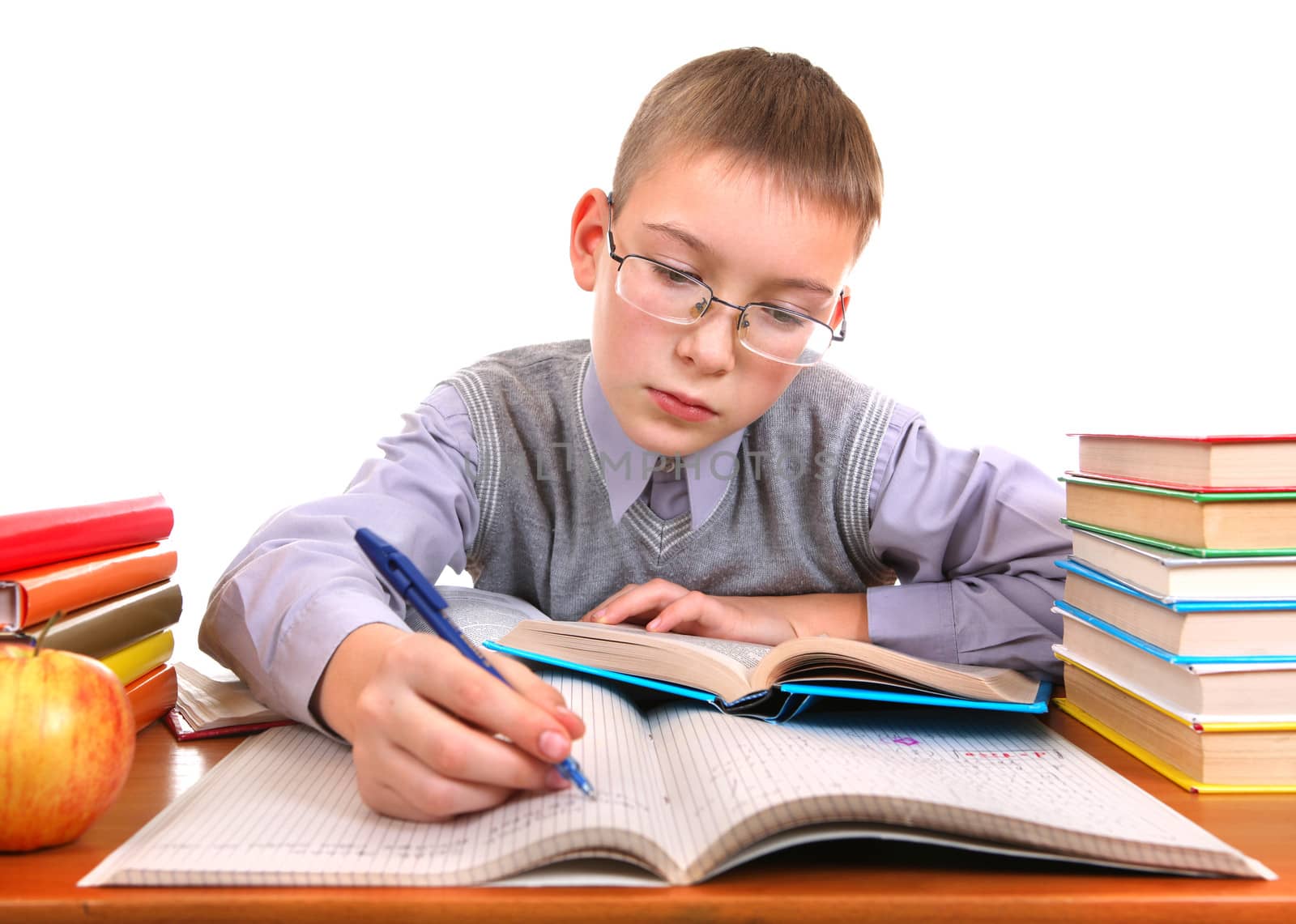 Schoolboy writing at the School Desk on the white background