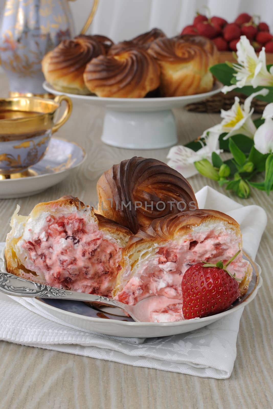 éclairs    with cream filling and slices of fresh strawberries