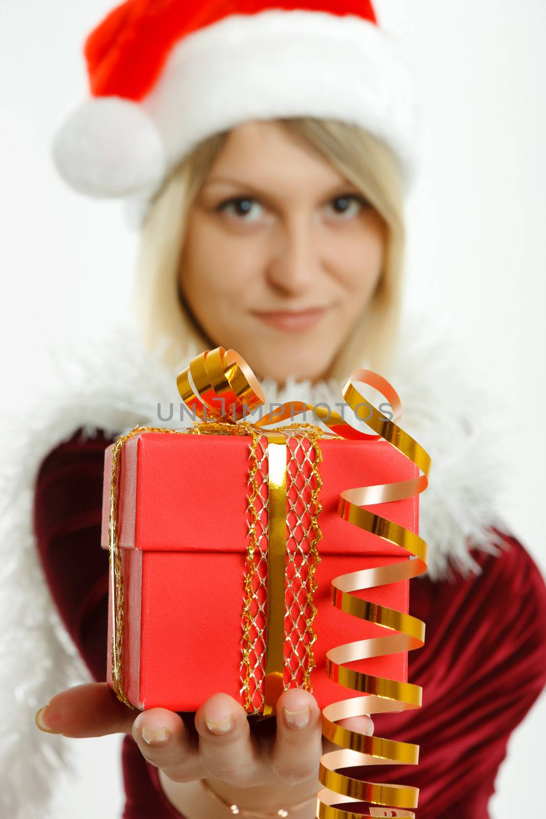 Beautiful girl in Santa hat with a gift