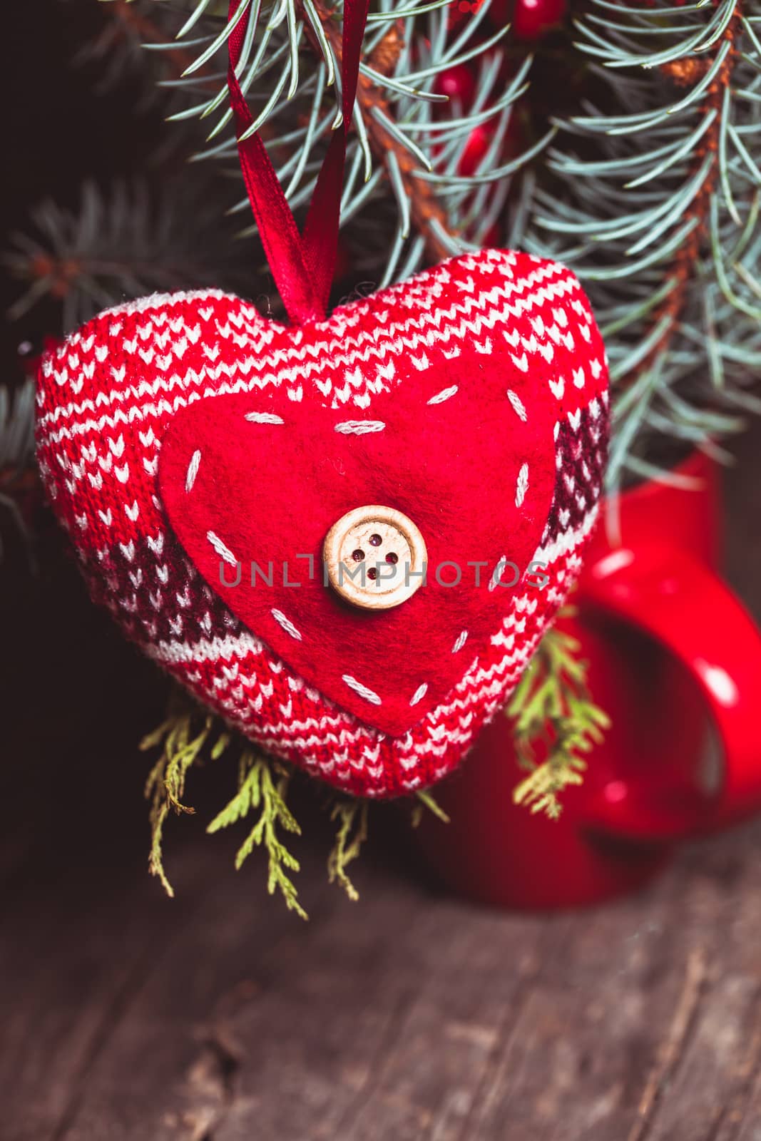 Handmade knitted heart - christmas decoration on the fir branch