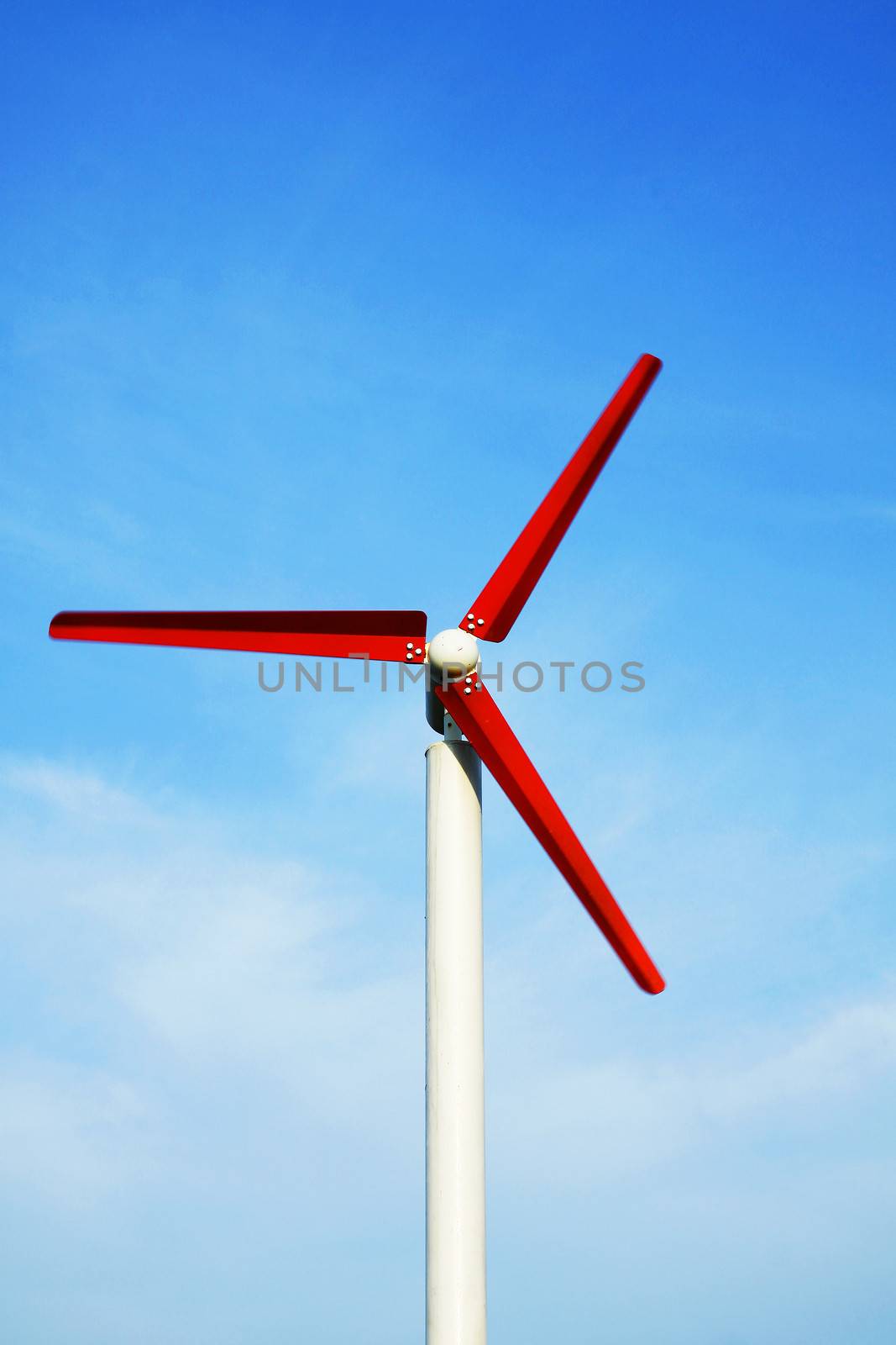Red wind turbine working with blue sky