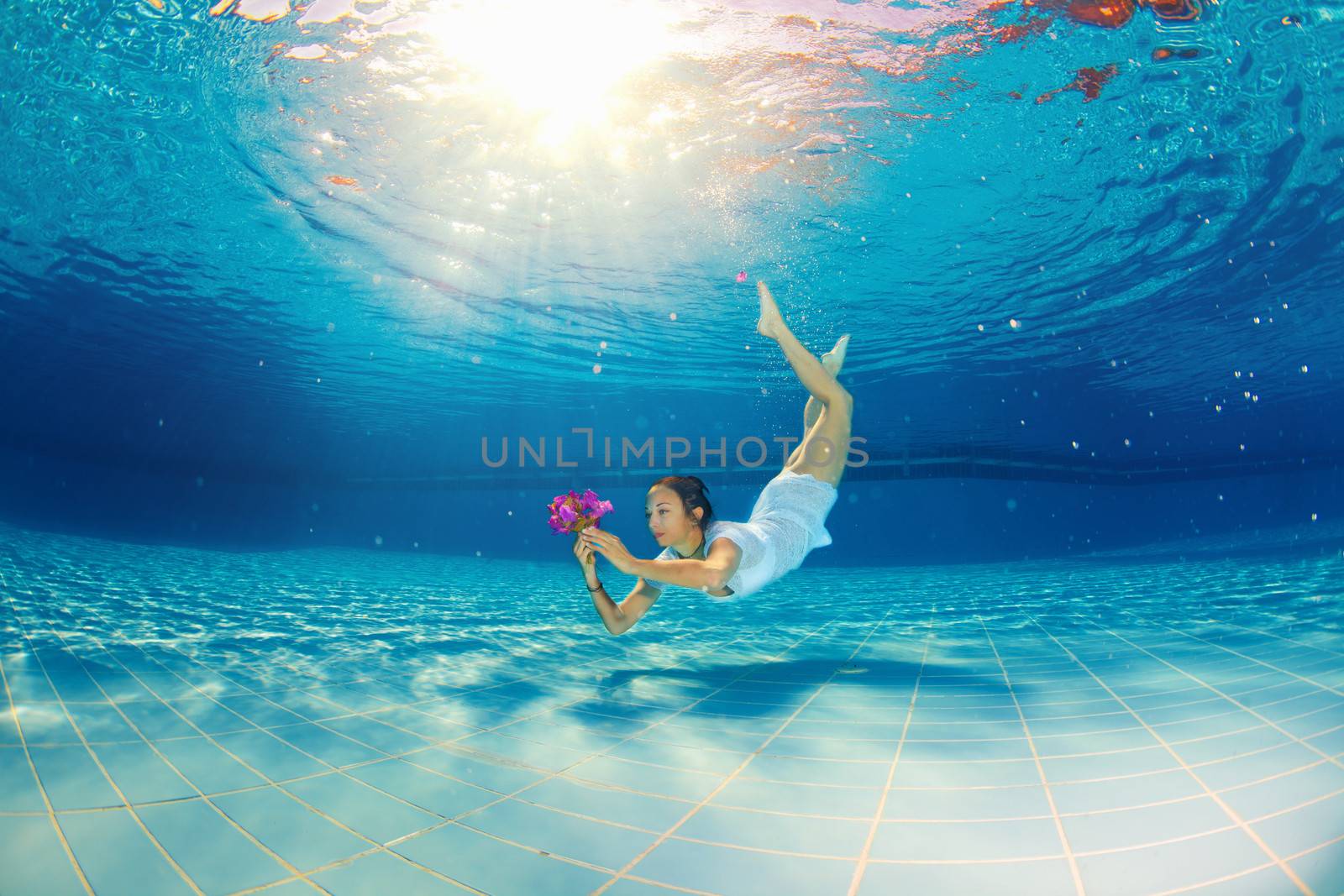  girl diving under the water with flowers