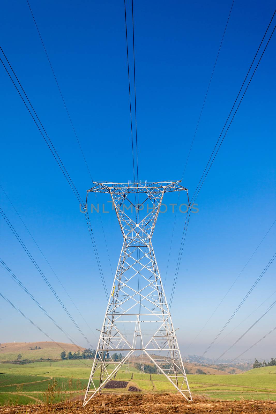 Electricity cables attached to steel structure towers transport electrical power supply over the countryside landscape