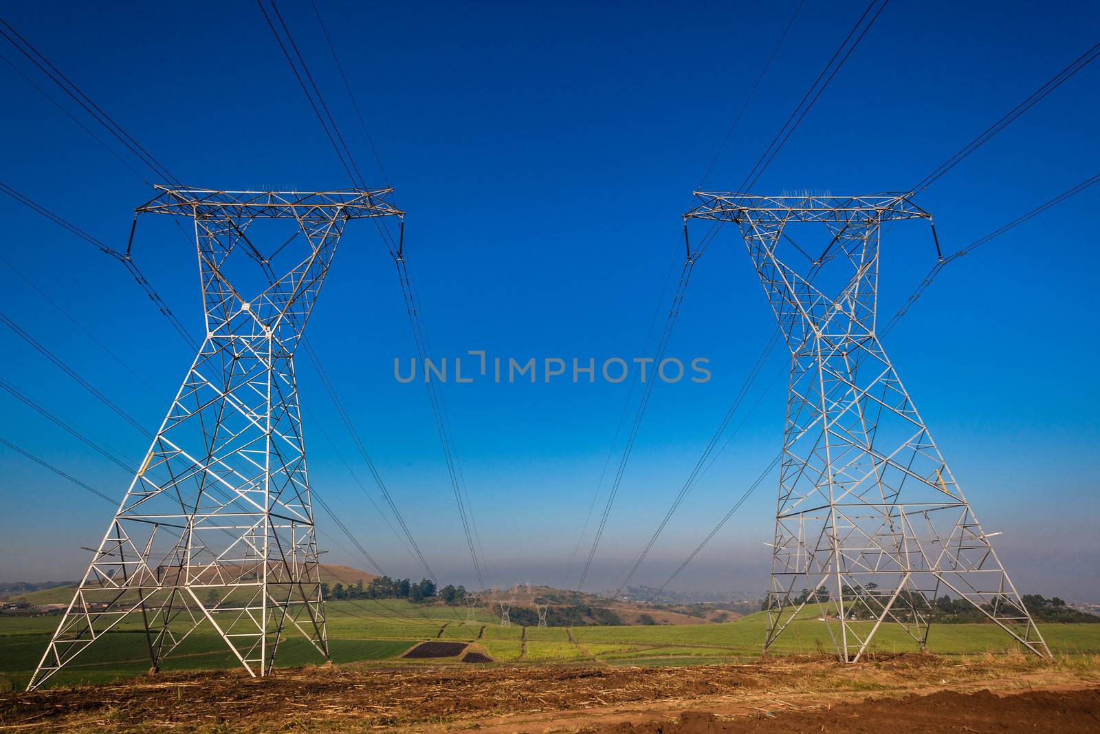 Electricity cables attached to steel structure towers transport electrical power supply over the countryside landscape