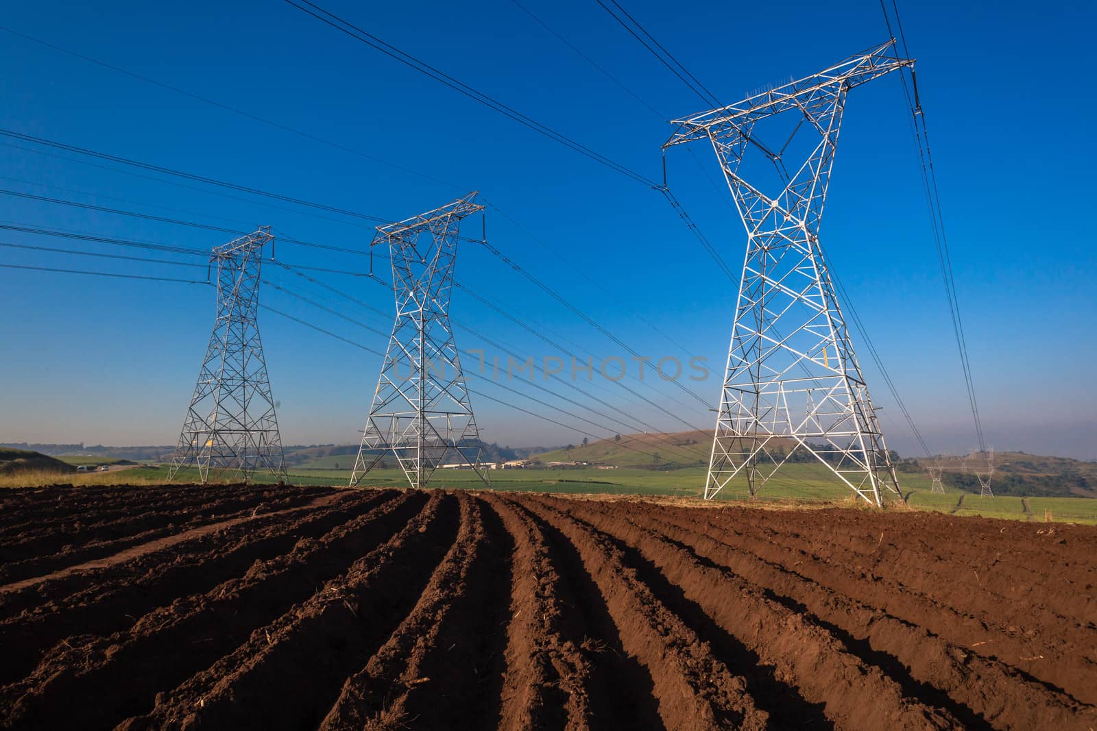 Electricity cables attached to steel structure towers transport electrical power supply over the countryside landscape