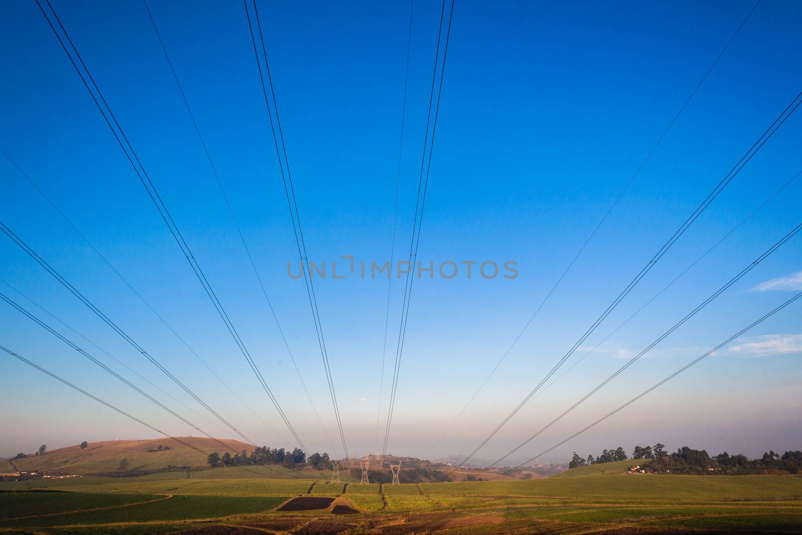 Electricity cables attached to steel structure towers transport electrical power supply over the countryside landscape