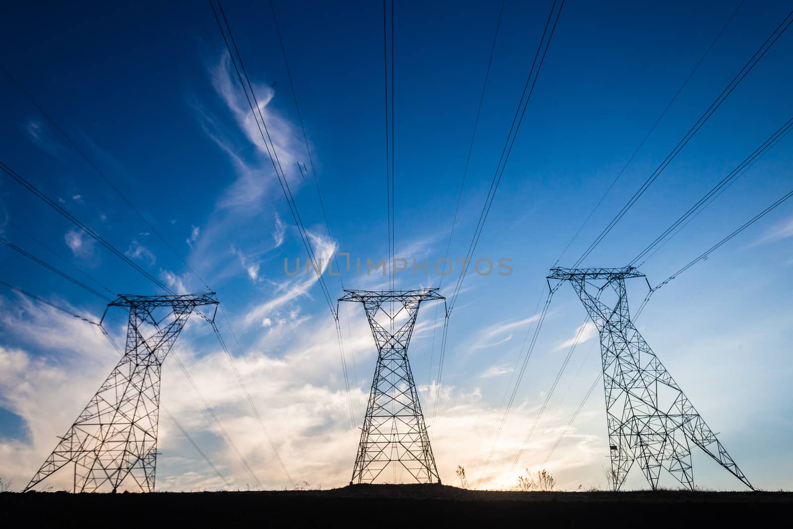 Electricity cables attached to steel structure towers transport electrical power supply over the countryside landscape