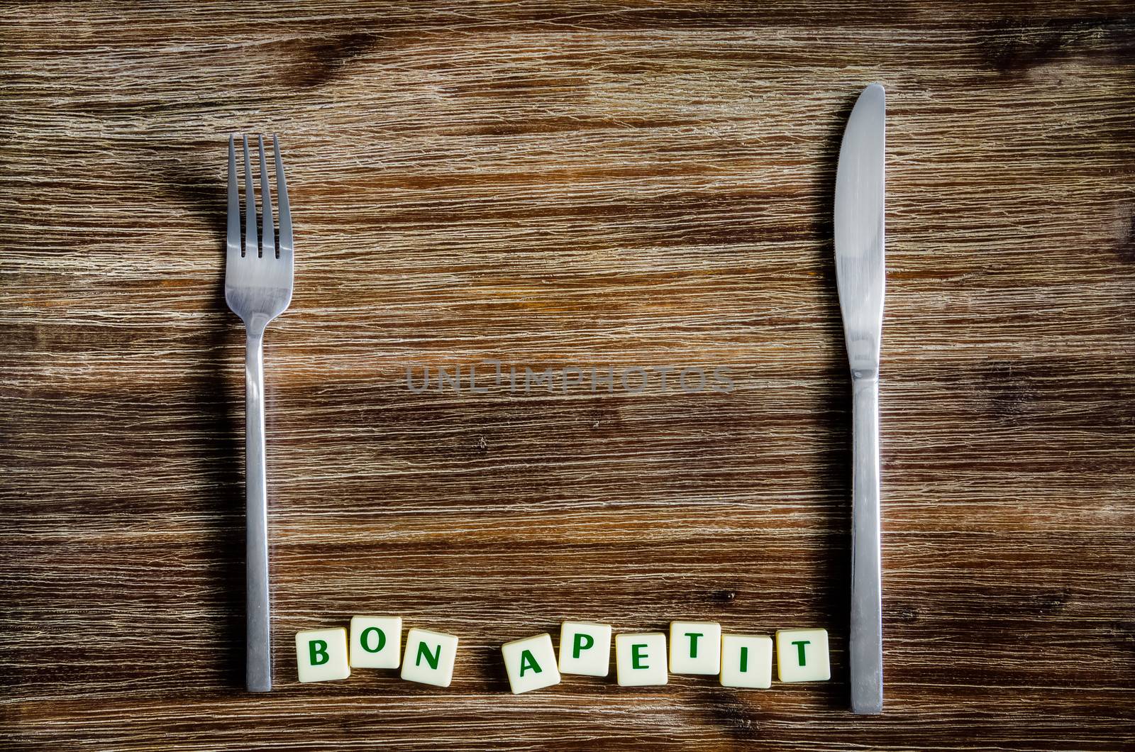 Silverware on the vintage wooden table and Bon apetit sign