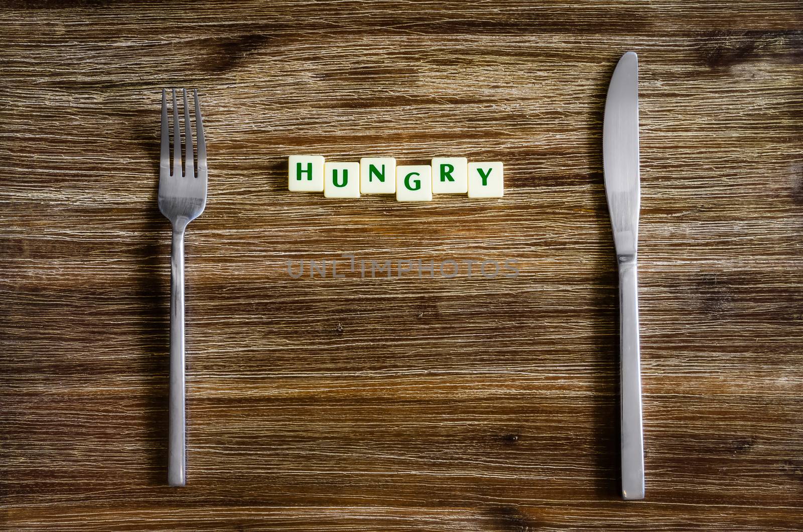 Silverware set on a wooden vintage table with sign Hungry