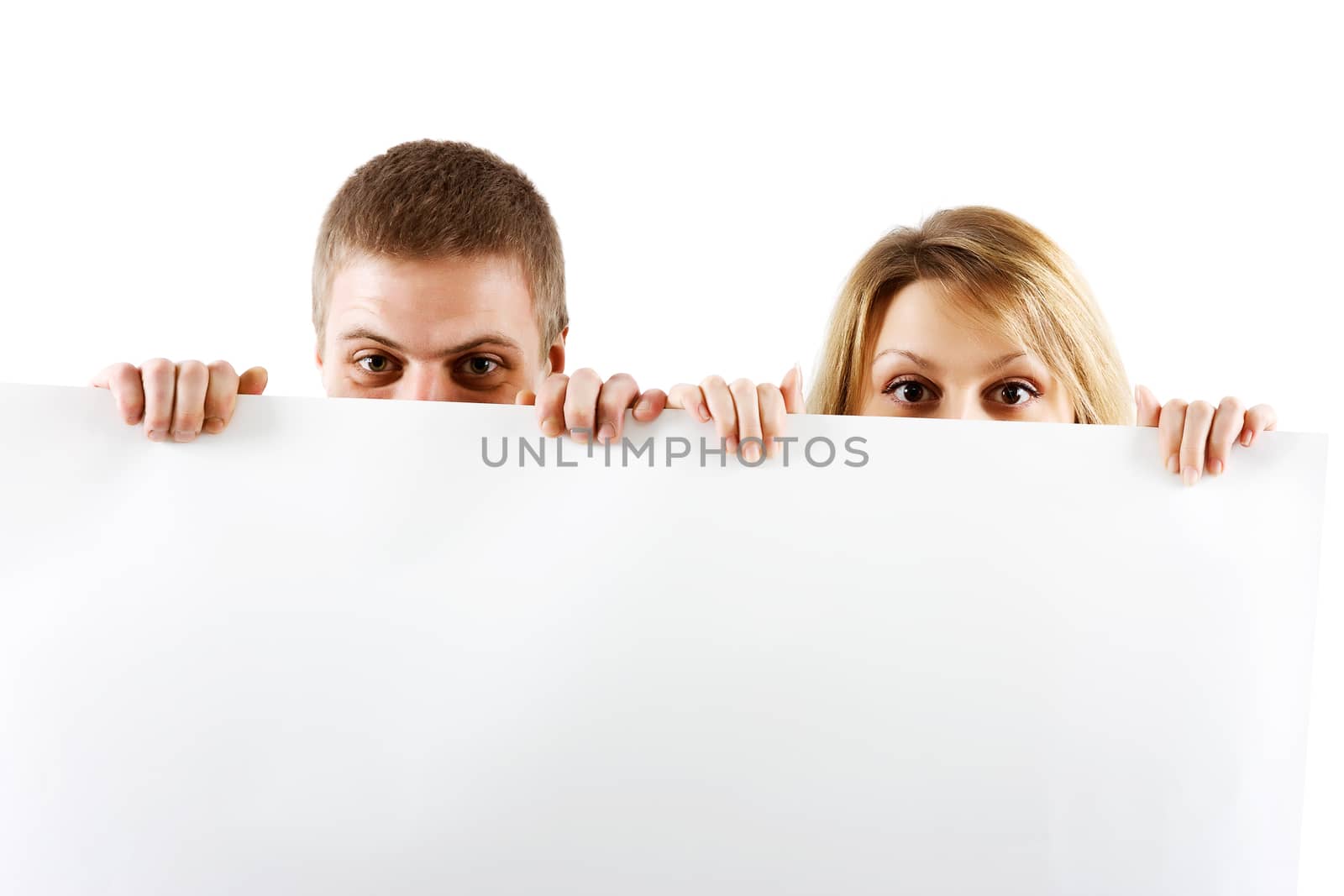 Young couple peeking out from behind the booth