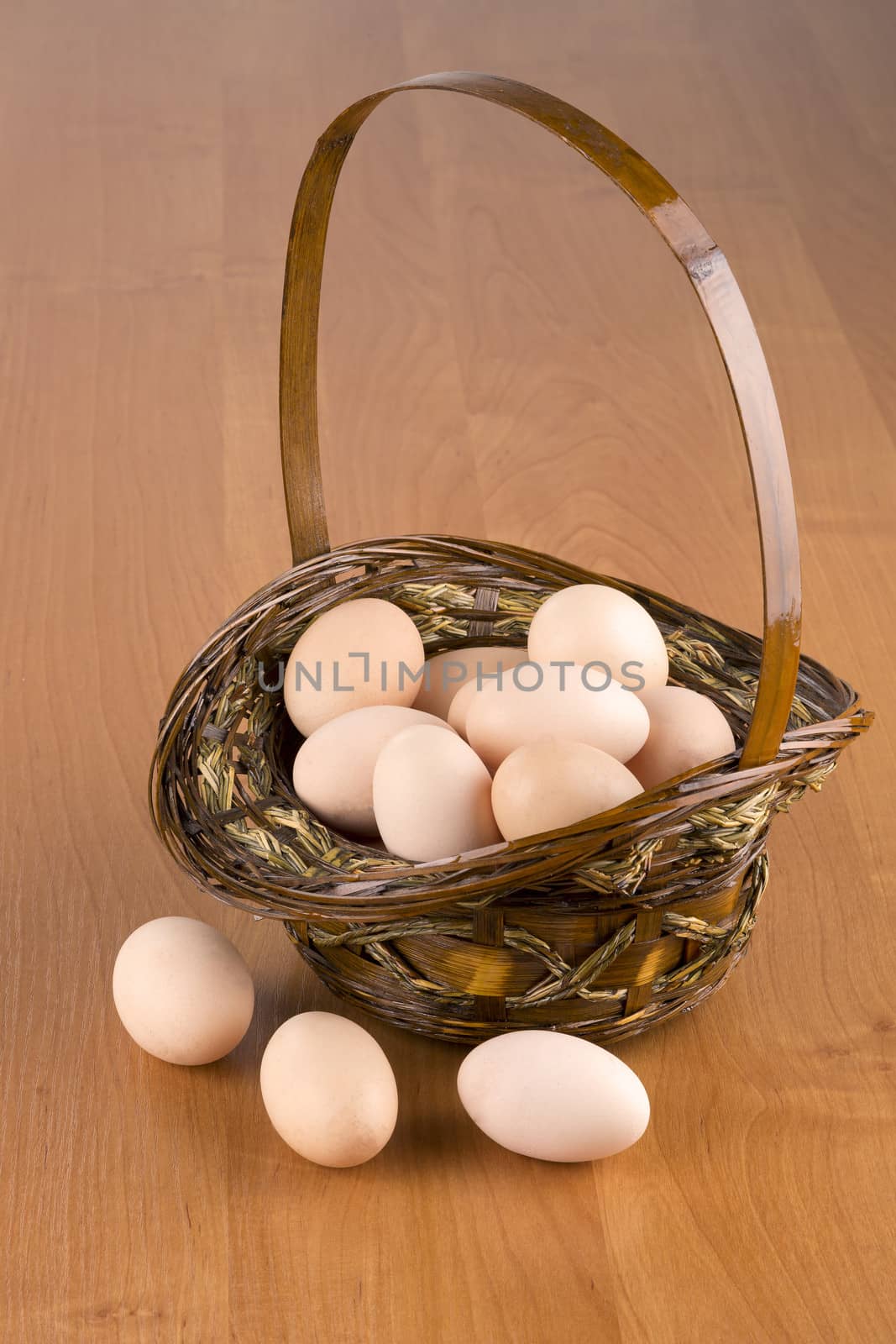 Fresh eggs in a basket on a wooden background