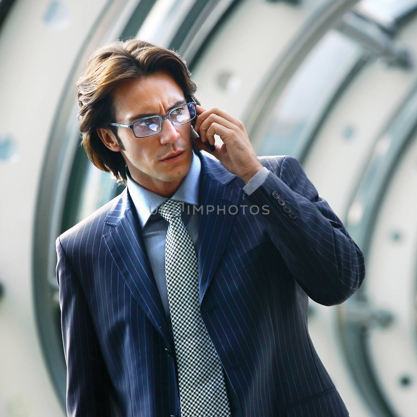 Businessman talking on mobile phone in office lobby 
