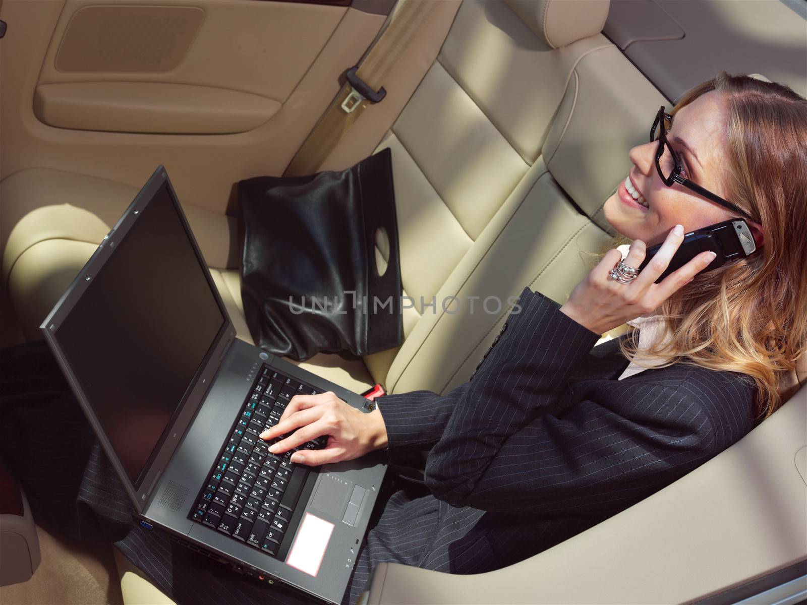 businesswoman has a fan with laptop in black car 