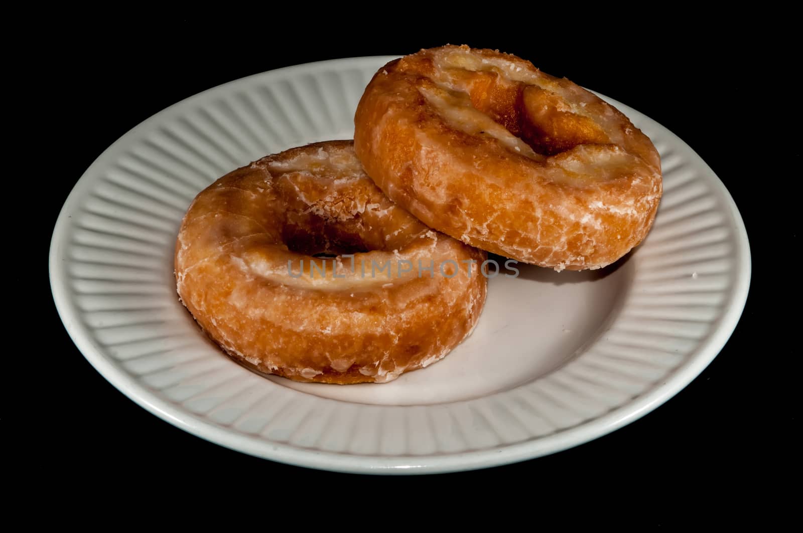 two Glazed Donuts Isolated on a Black Background