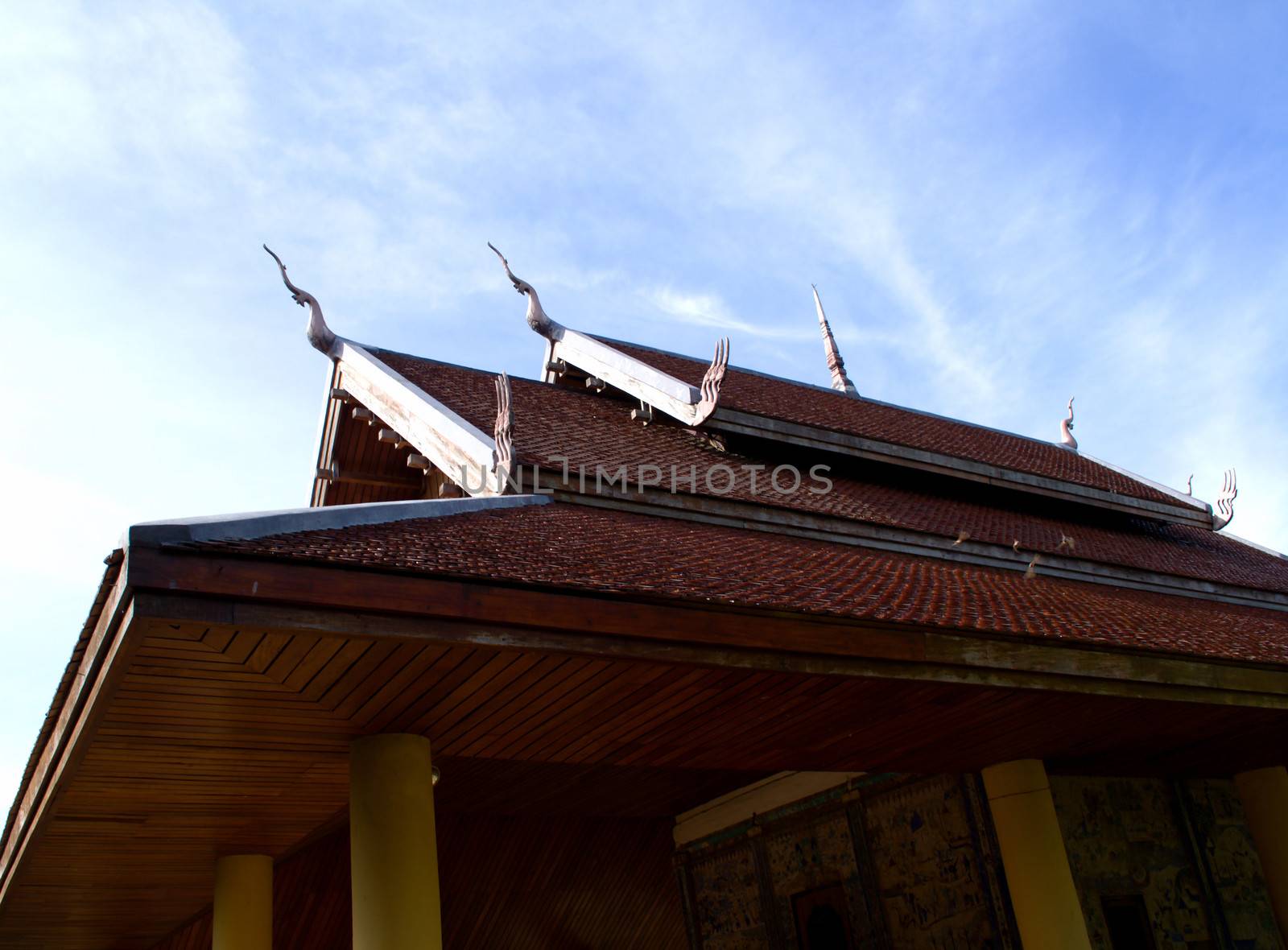 Roof of old temple with blue sky in Thailand