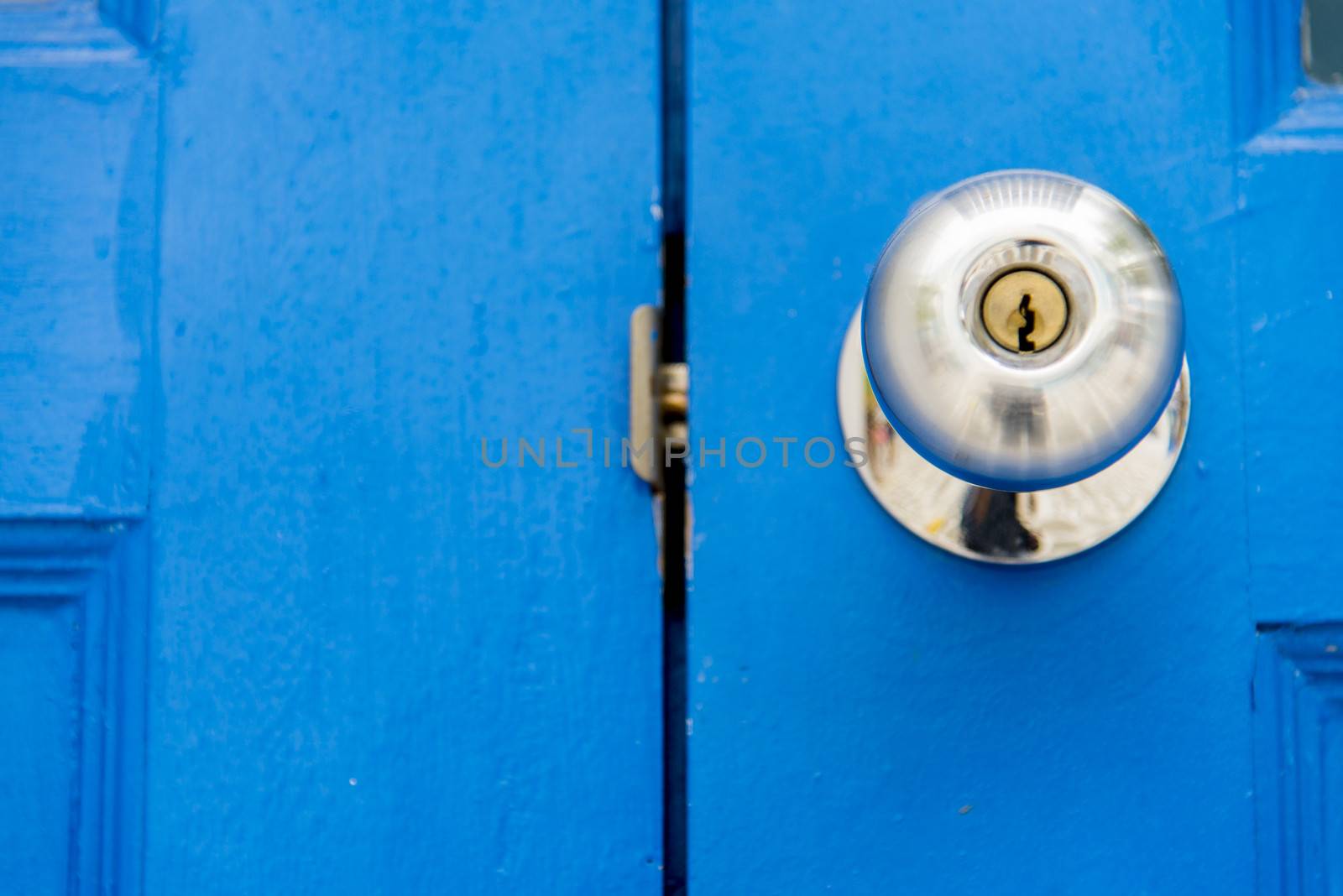 Stainless handle on blue wooden door3 by gjeerawut