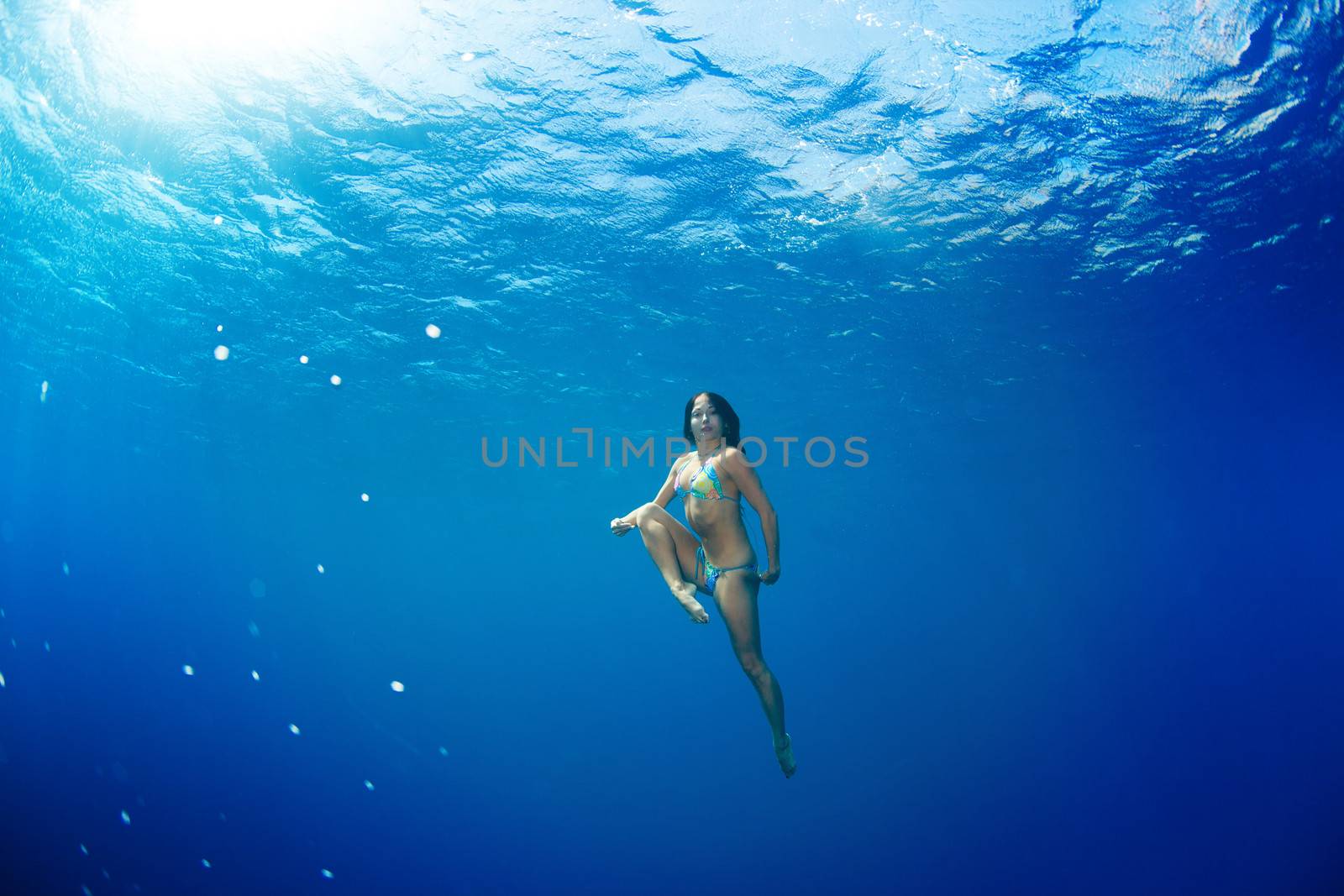 athletic girl diving under the sea