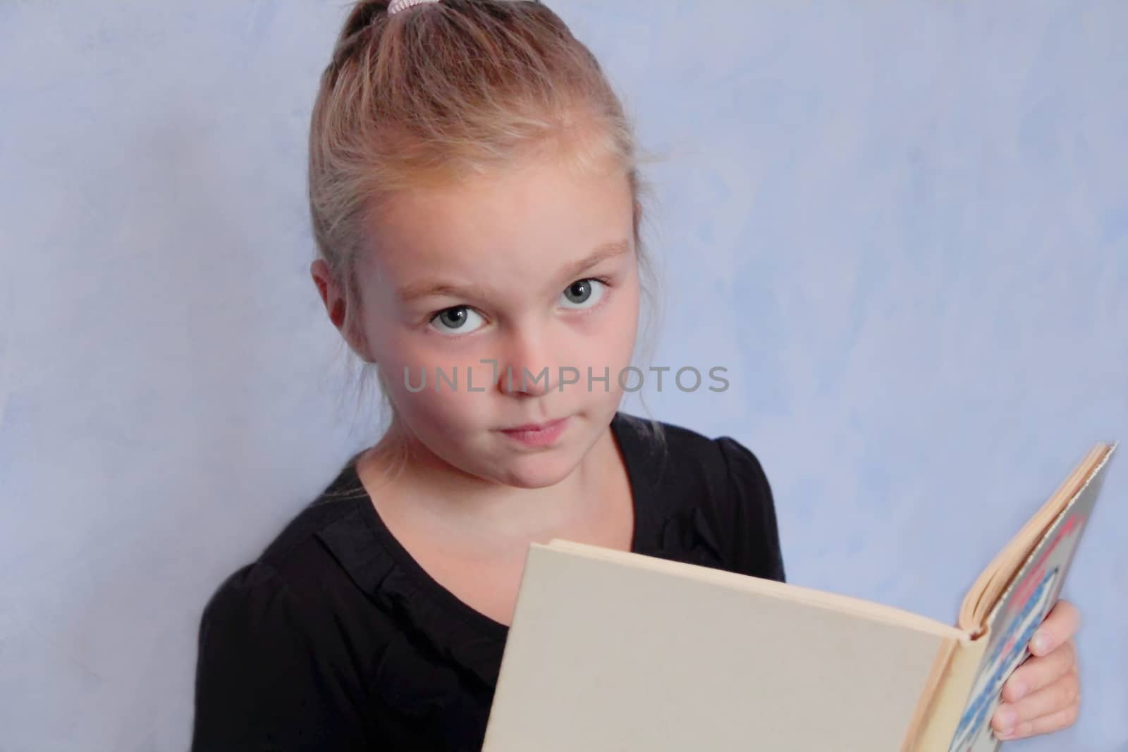 Portrait of girl with blond hair reading a book
