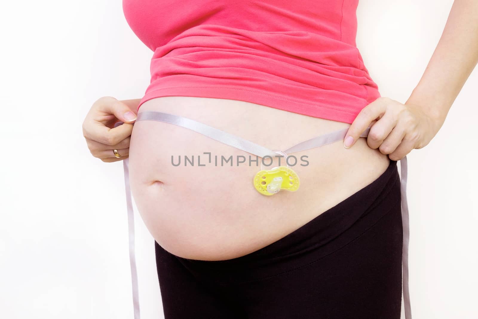 Pregnant woman holding dummy on ribbon