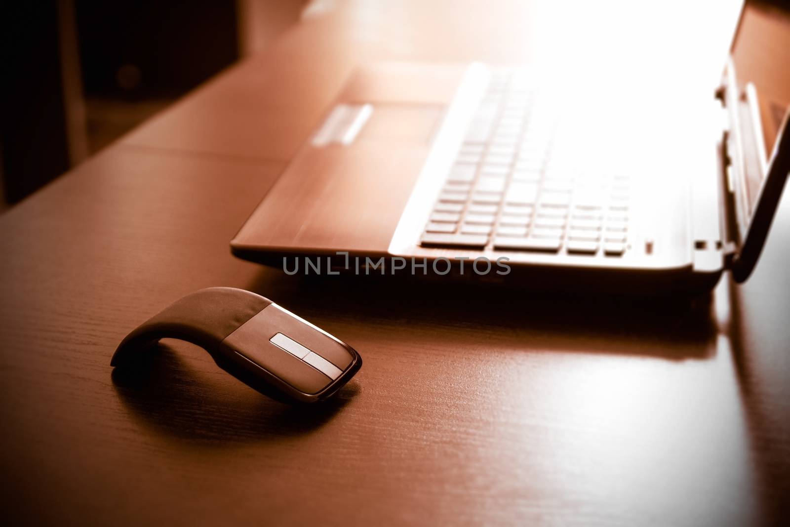 Human hand on computer mouse. Laptop on desk.