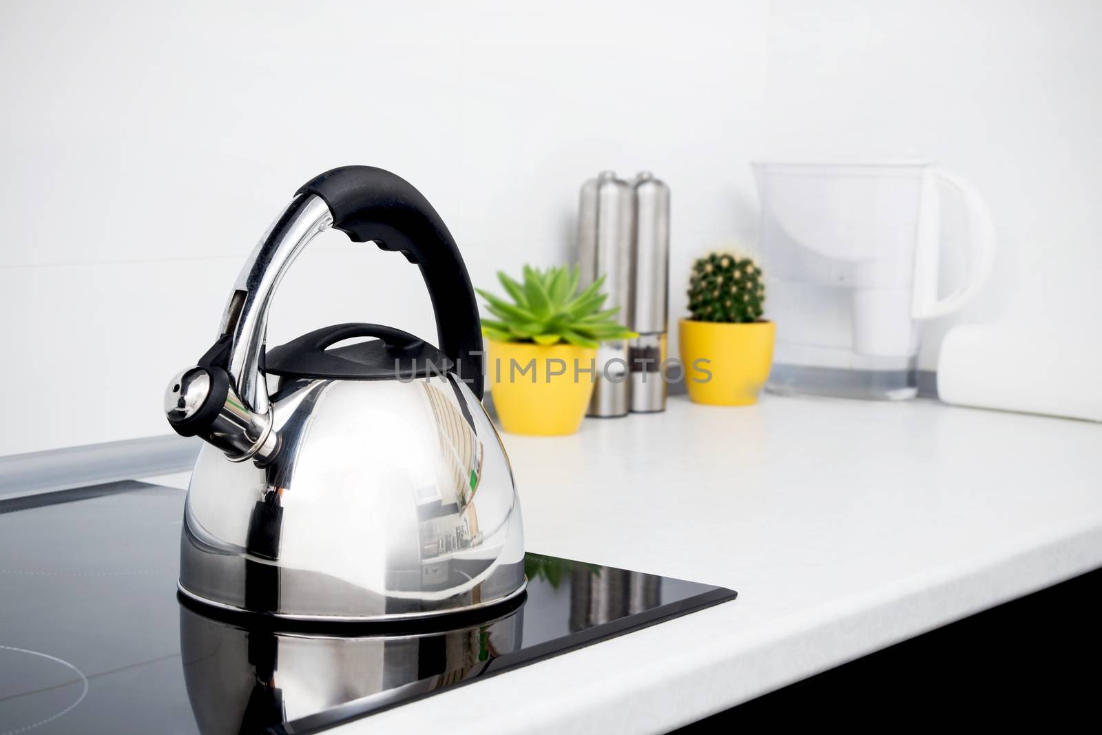 Steel kettle in modern kitchen with induction stove  by simpson33