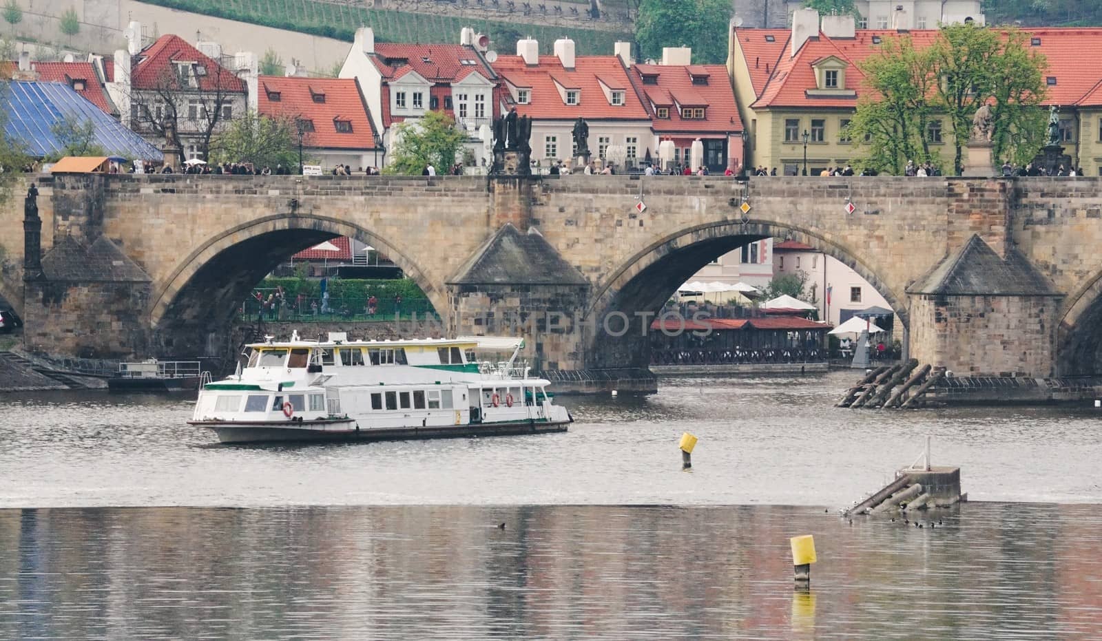 View of Prague. Vltava River at Charles Bridge and sailing passenger ship