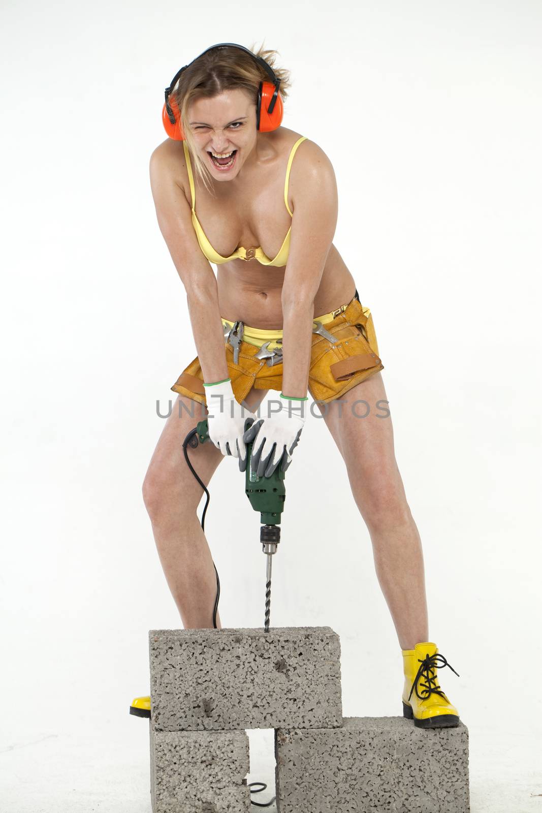 Young sexy woman holding a construction drill