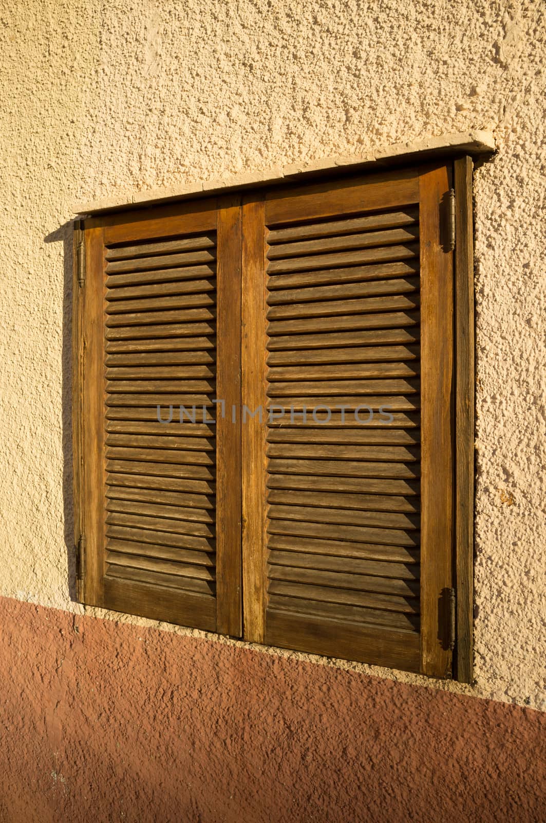Mediterranean window with traditional closed wooden shutters