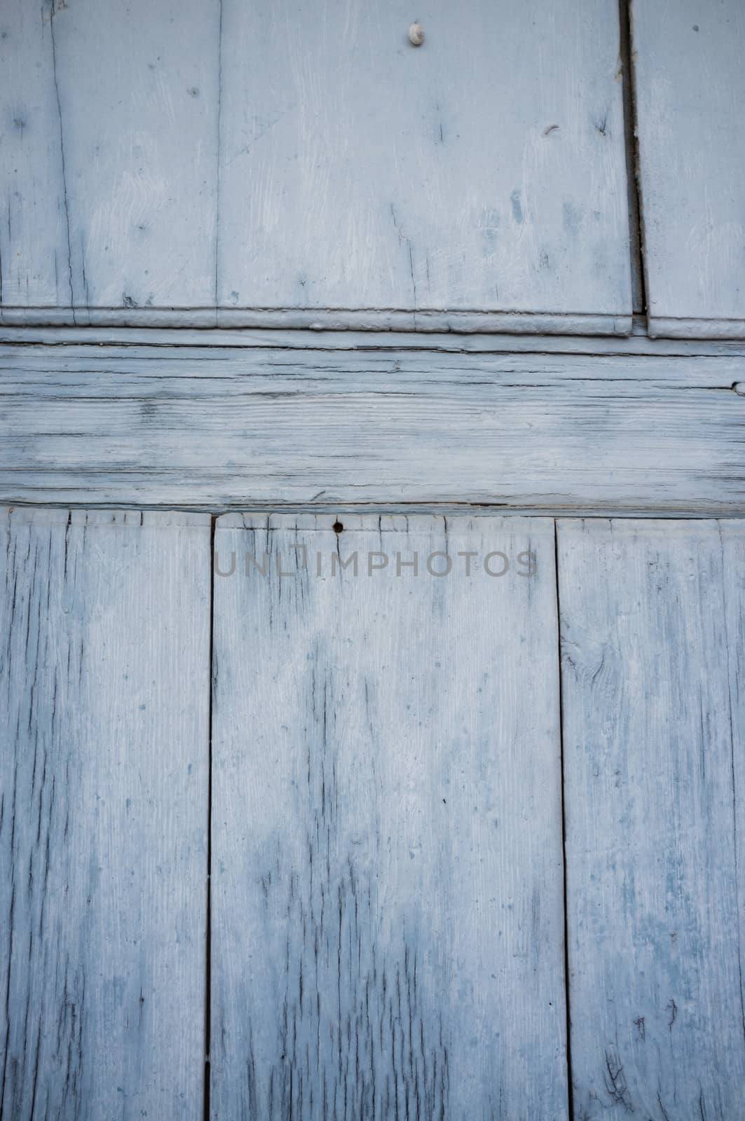 Weathered planks of an old blue wooden door