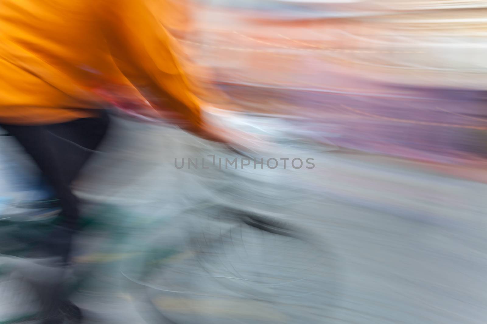 Abstract image of cyclist in motion blur with blurred urban background