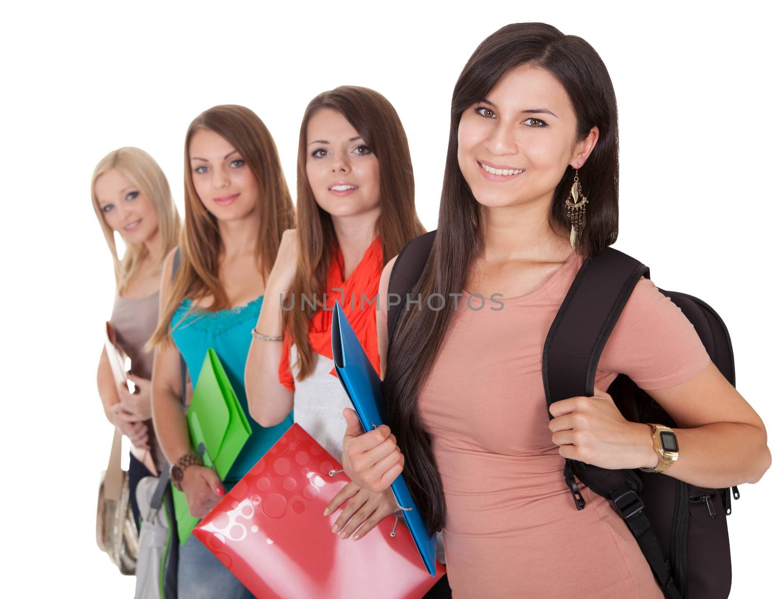 Four beautiful young female students standing in a receding row with folders of notes under their arms isolated on white