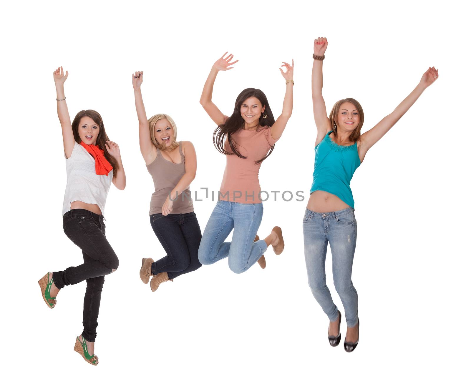 Four excited young woman jumping for joy with their hands raised in the air in celebration isolated on white