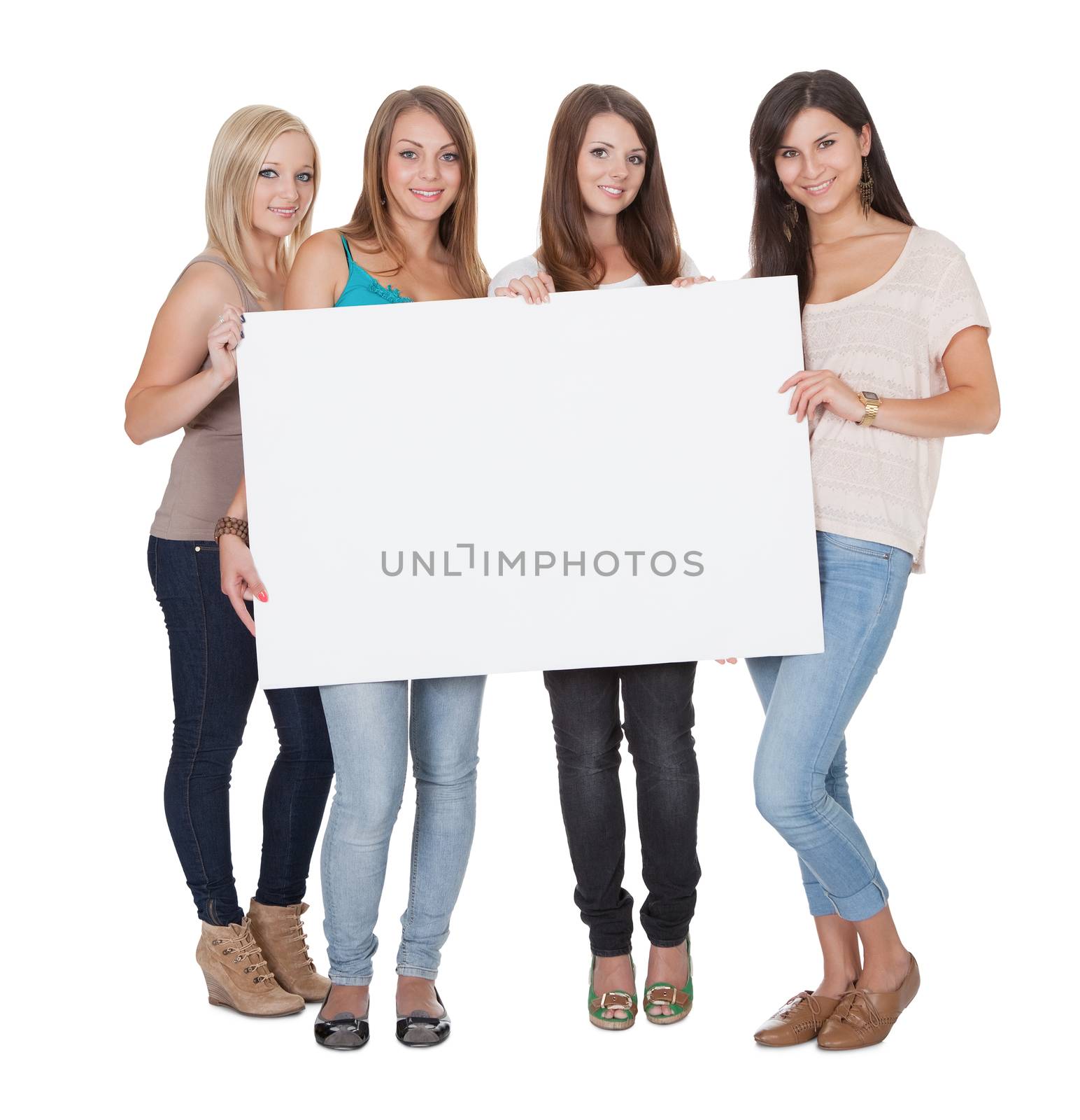 Four attractive girls holding a white board by AndreyPopov