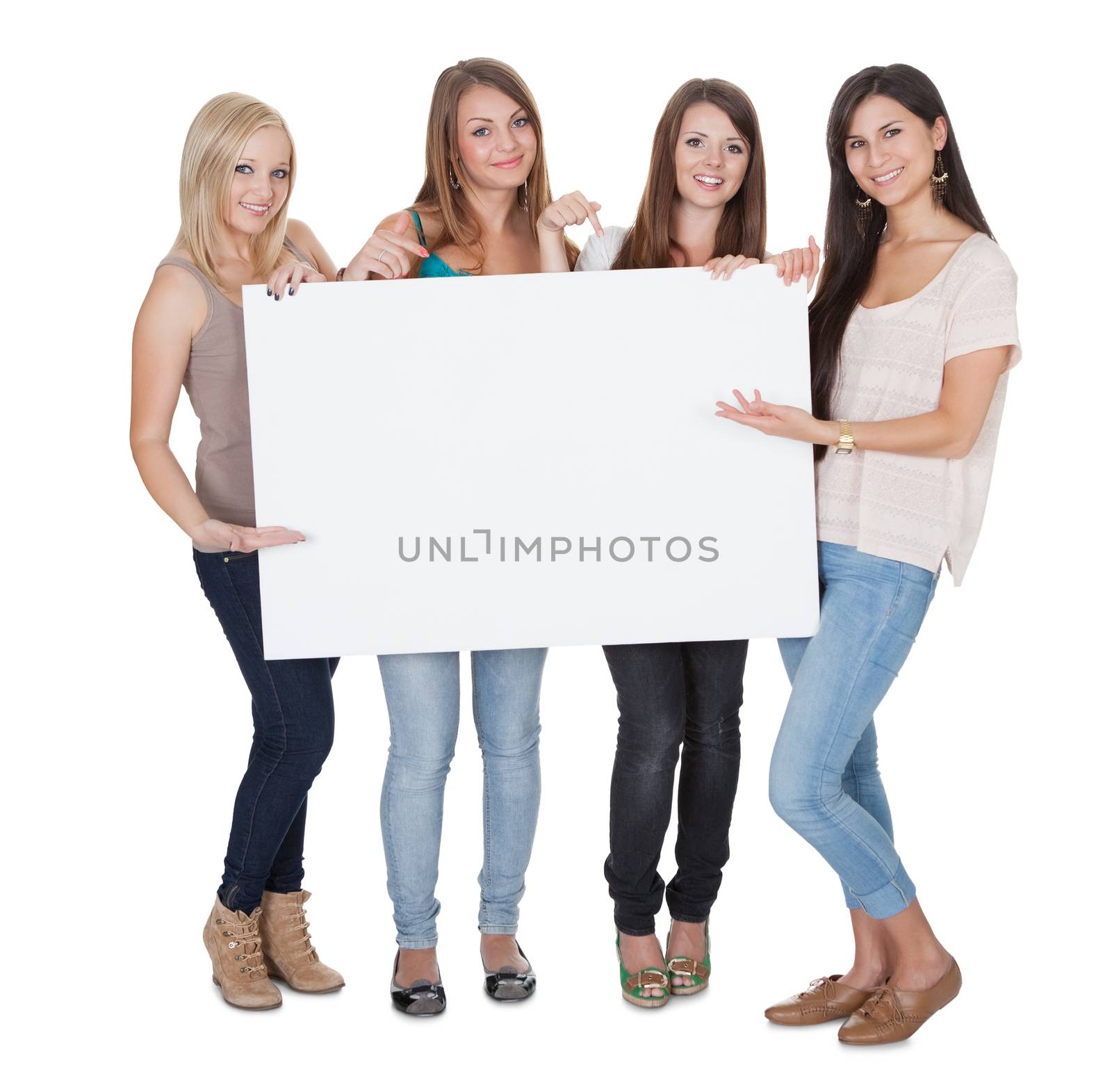 Studio shot of four attractive girls with a blank white board isolated on white