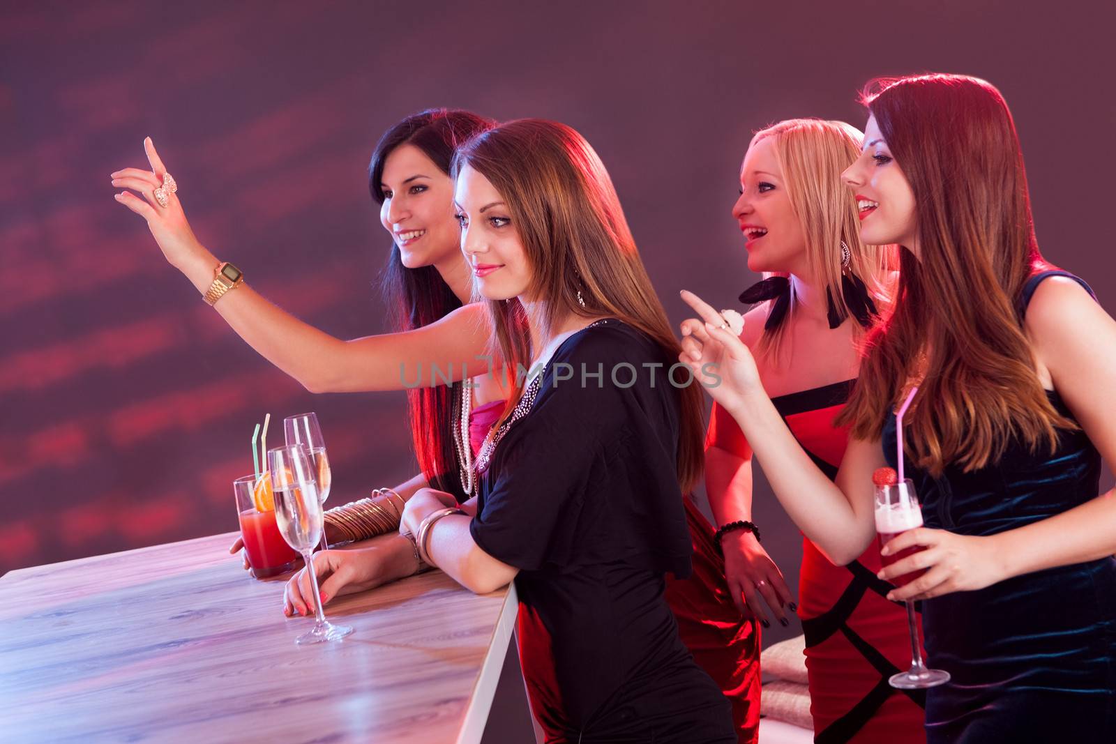 Beautiful girls ordering drinks at the bar by AndreyPopov