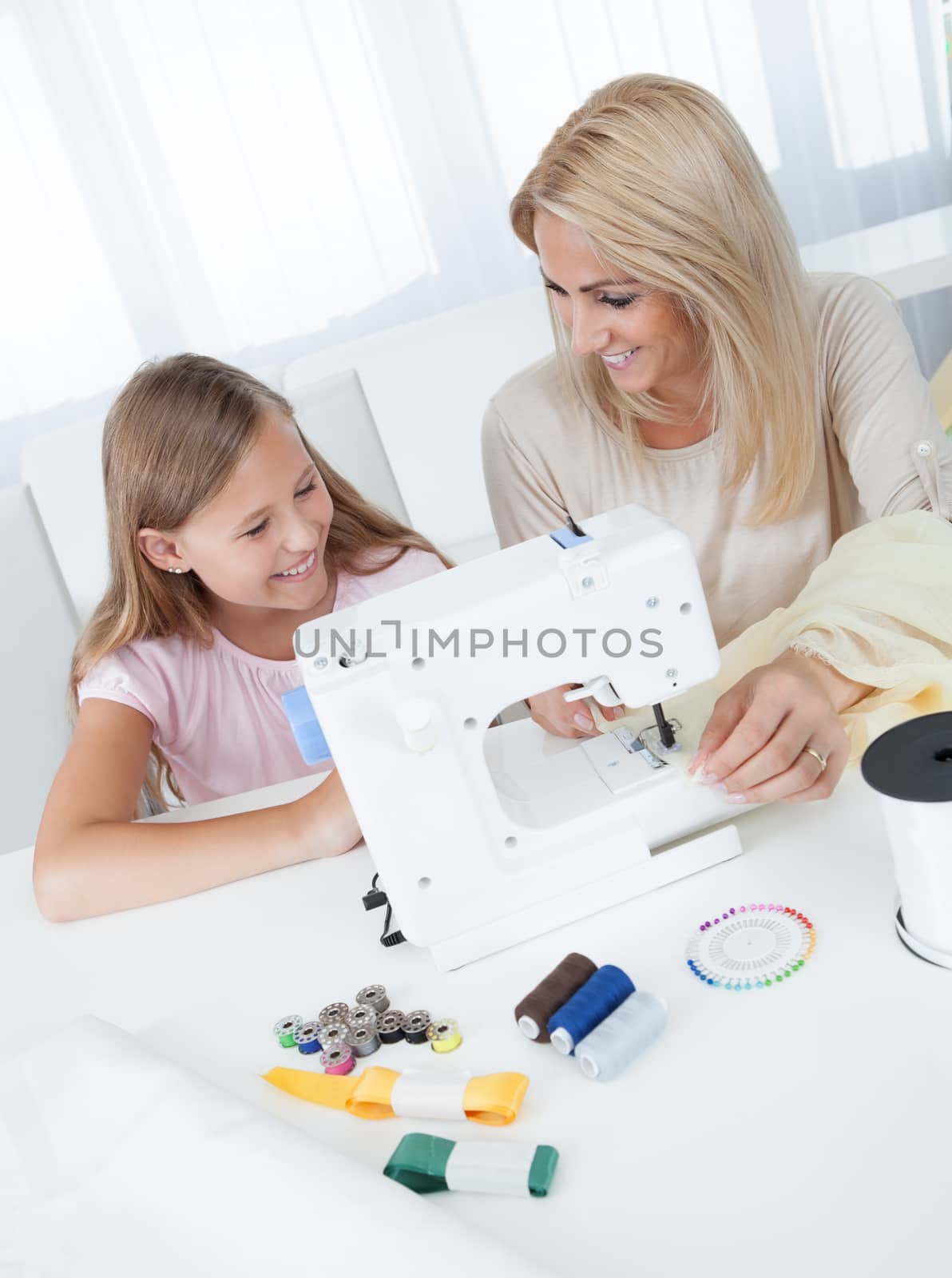 Beautiful Young Girl Sewing With Her Mother by AndreyPopov