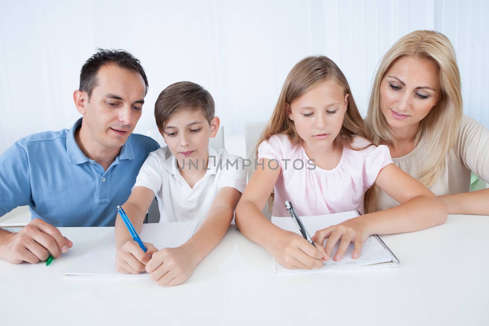 Parents Helping Their Children With Their Homework At Home