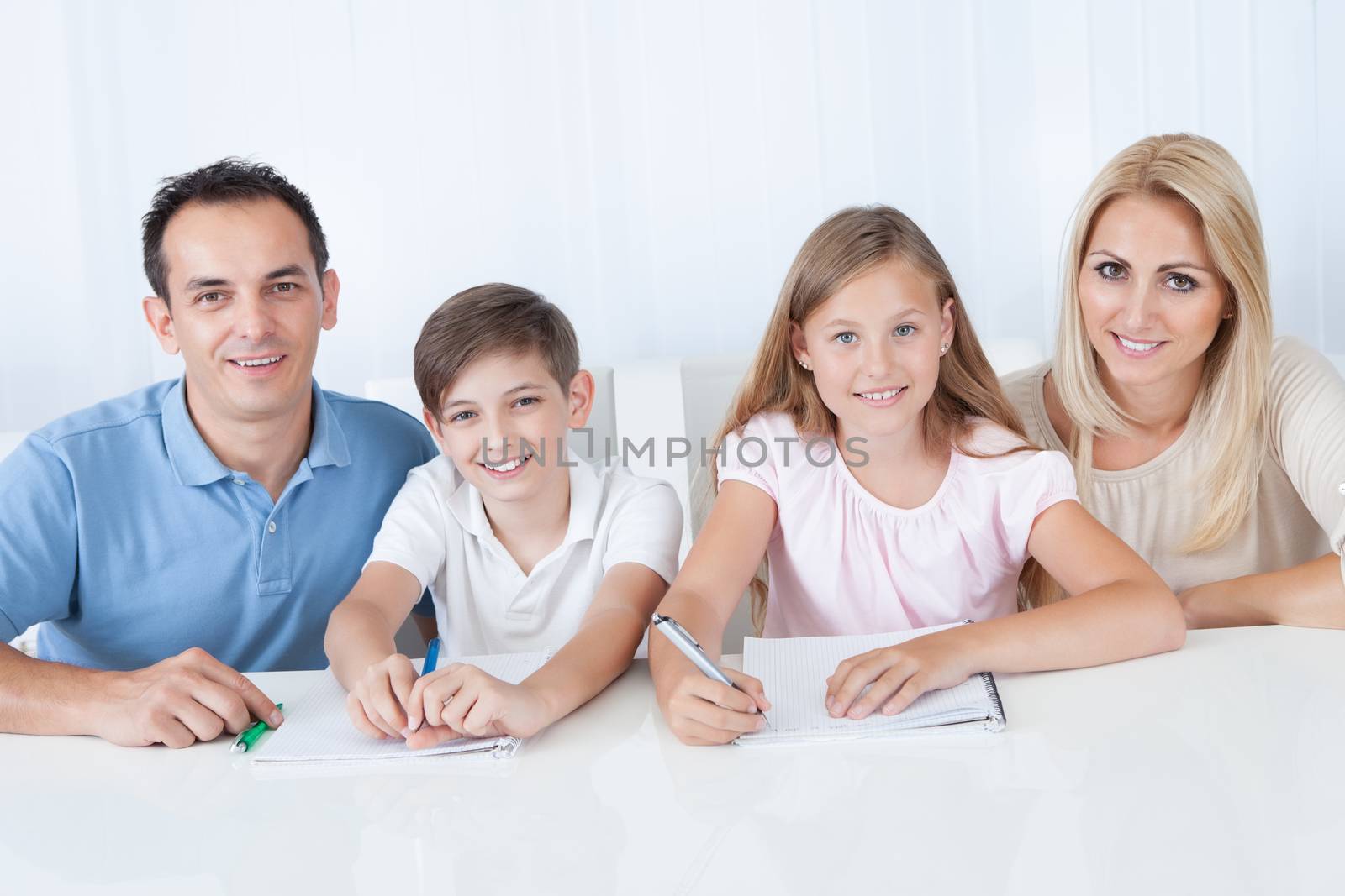 Parents Helping Their Children With Their Homework At Home